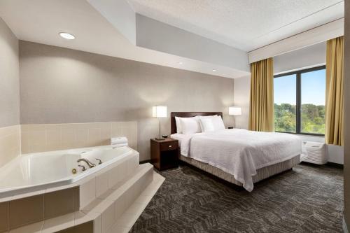 斯特灵春山杜勒斯机场套房酒店的酒店客房配有一张床和浴缸。