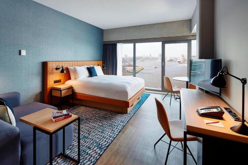 阿姆斯特丹阿姆斯特丹木材港万豪原住客栈的配有一张床和一张书桌的酒店客房