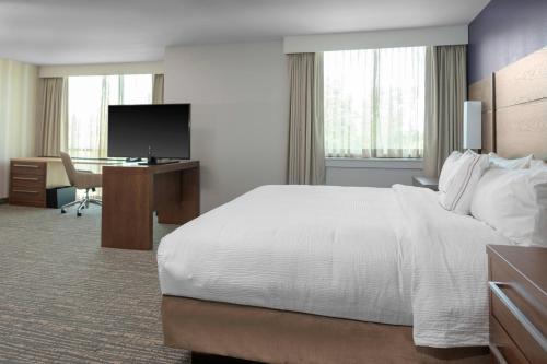 弗吉尼亚海滩Residence Inn by Marriott Virginia Beach Town Center的酒店客房设有一张大床和一张书桌。