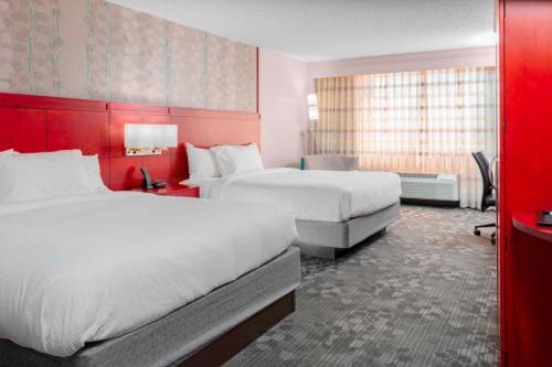 基林基林万怡酒店的酒店客房设有两张床和红色的墙壁。