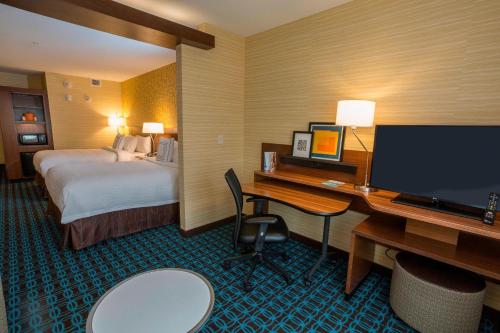 日内瓦Fairfield Inn & Suites by Marriott Geneva Finger Lakes的酒店客房配有一张床和一张带电脑的书桌