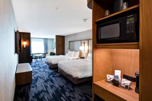 普里茅斯Fairfield Inn & Suites by Marriott Plymouth的酒店客房设有两张床和一台平面电视。