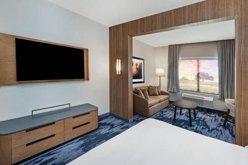 休斯顿Fairfield Inn & Suites Houston Memorial City Area的配有一张床和一台平面电视的酒店客房