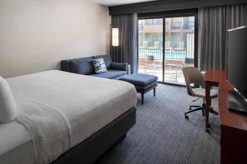 托伦斯洛杉矶托伦斯/帕洛斯弗德斯万怡酒店的酒店客房配有一张床、一把椅子和一张书桌