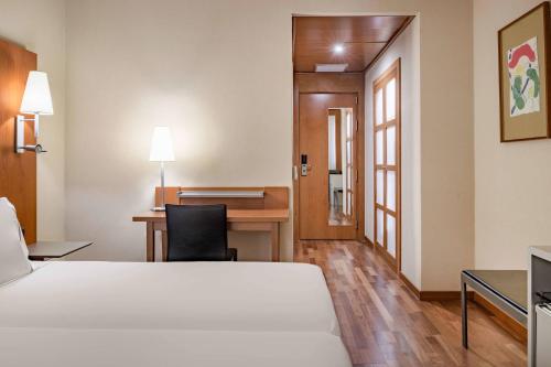 热那亚热那亚万豪AC酒店的配有一张床和一张书桌的酒店客房