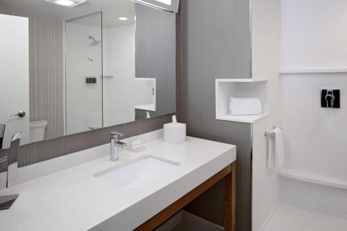 达拉斯Courtyard by Marriott Dallas Downtown/Reunion District的白色的浴室设有水槽和镜子