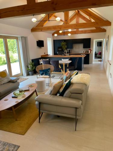 邓弗里斯The Stables - Luxury Cottage的客厅配有沙发和桌子
