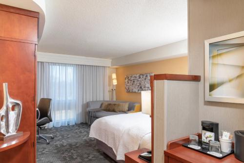 密尔沃基密尔沃基机场万怡酒店的酒店客房设有床和客厅。