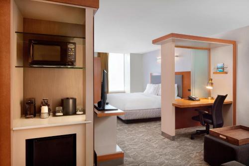 印第安纳波利斯印第安纳波利斯市中心春季山丘套房的酒店客房配有一张床和一张书桌及一台电视