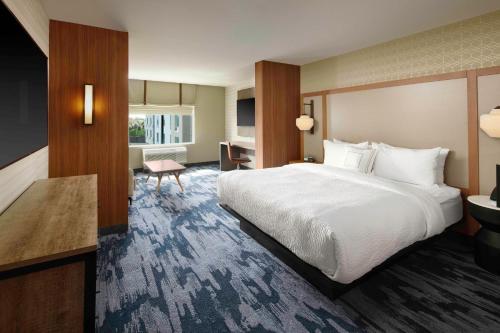路易斯威尔Fairfield Inn & Suites By Marriott Louisville Northeast的酒店客房设有一张大床和一张书桌。