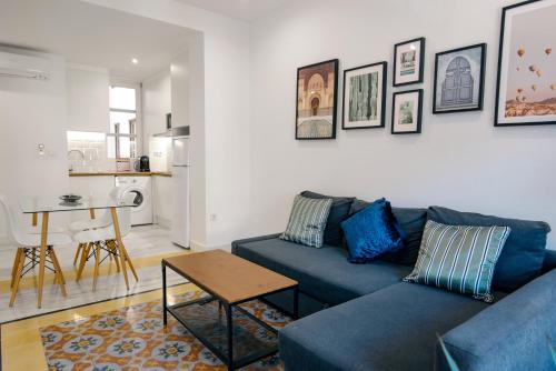 格拉纳达Granadi Apartamentos的客厅配有蓝色的沙发和桌子
