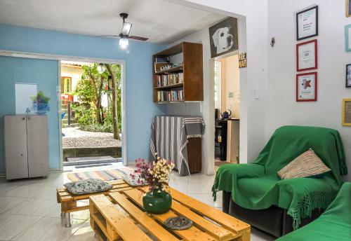 里约热内卢Eco Pousada Estrelas da Babilônia的客厅配有桌子和绿色椅子