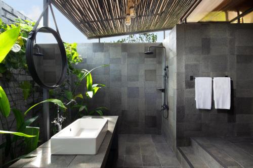 拉古洼Natra Bintan, a Tribute Portfolio Resort的浴室配有水槽和植物淋浴