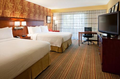 SorrentoCourtyard by Marriott San Diego Sorrento Valley的酒店客房设有两张床和一台平面电视。