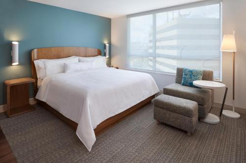 米西索加Element Toronto Airport的卧室配有床、椅子和窗户。