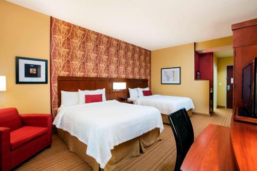 霍姆斯泰德迈阿密家园万怡酒店的酒店客房,设有两张床和一张红色椅子