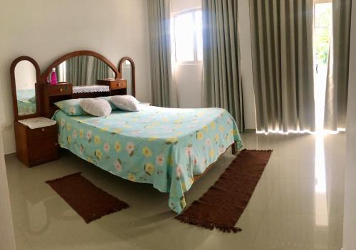 圣克鲁斯Casa Beni para estrenar的一间卧室配有一张带蓝色毯子和镜子的床