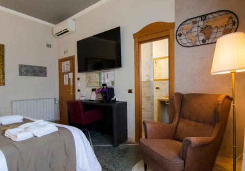 比萨玛丽亚酒店的酒店客房配有一张床、一把椅子和一张书桌