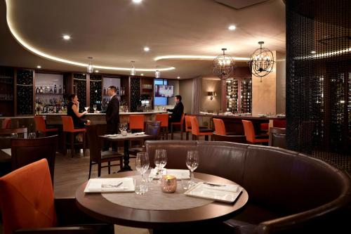 魁北克市Marriott Quebec City Downtown的一间带桌椅的餐厅和一间酒吧