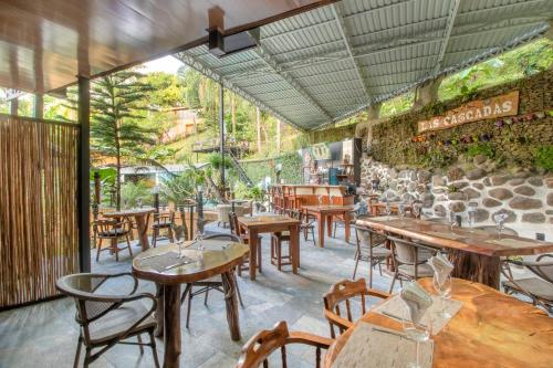 曼努埃尔安东尼奥Boutique Hotel Las Cascadas的一间带桌椅和石墙的餐厅