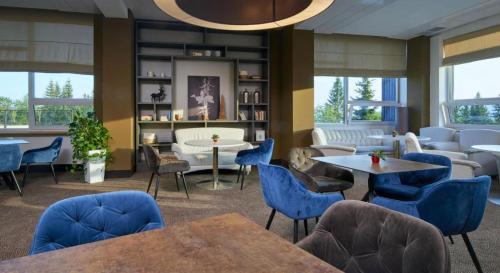 泽勒兹纳·鲁达OREA Resort Horizont Šumava的一间设有蓝色椅子和桌子的等候室