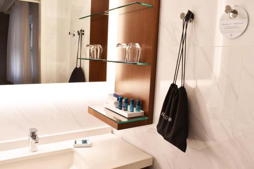 印第安纳波利斯Delta Hotels by Marriott Indianapolis East的浴室设有水槽,墙上装有黑袋