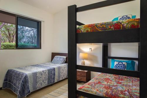 里瓦斯Eco Casita Phase III #2: Casa de Olas的一间卧室设有两张双层床和一扇窗户。