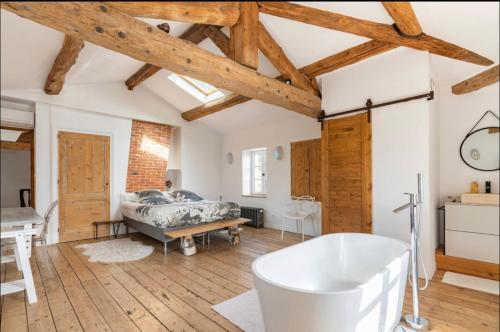 塔桑拉德米吕讷Aux Tourelles 1888 - tres proche Lyon的一间带浴缸的浴室,位于一间设有木制天花板的客房