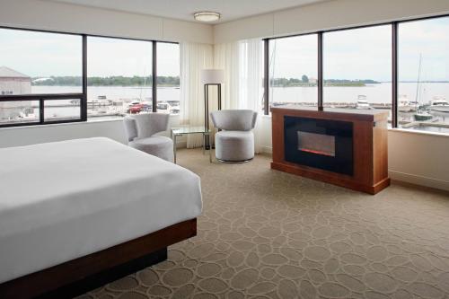 金斯顿三角洲金斯顿海滨万豪酒店的一间卧室配有一张床、一个壁炉和一台电视。