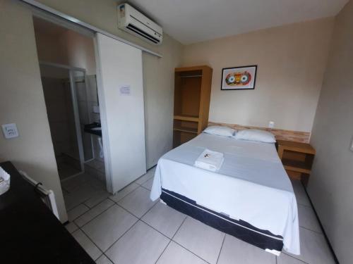 福塔莱萨Hotel Oiticica的一间带一张床和淋浴的小卧室
