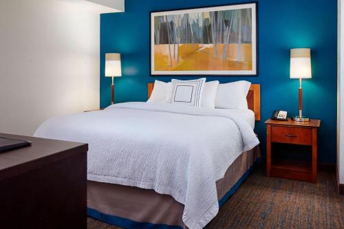 地球城圣路易斯机场/地球城原住客栈的一张大床,位于酒店客房,拥有蓝色的墙壁