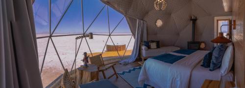 Salinas Grandes Jujuy - Pristine Luxury Camp的一间带沙发床的卧室,享有沙漠美景