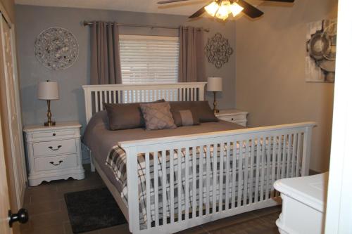 凤凰城Cozy Home.的卧室里一张白色的婴儿床,有2个床头柜