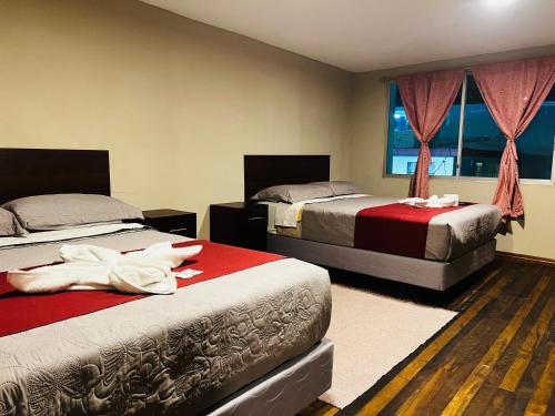 巴尼奥斯Casa de Joss的一间卧室设有两张床和窗户。