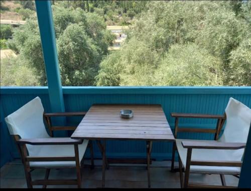 阿约斯尼奇塔斯Argo rooms的阳台上配有一张木桌和两把椅子