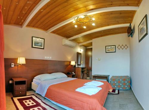 米蒂利尼TARLAS ROOMS的一间卧室设有一张床和木制天花板