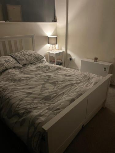 利物浦Cable Yard的卧室内的一张大床,桌子上有一盏灯