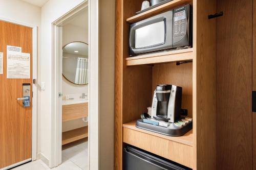 萨利纳Fairfield Inn & Suites by Marriott Salina的一间配有微波炉的房间和橱柜上的电视