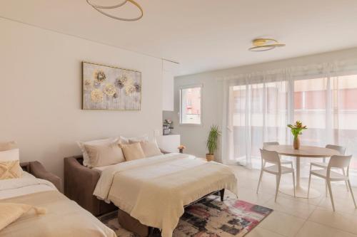 卢加诺Central Superior Suites - Free Parking的白色卧室配有两张床和一张桌子