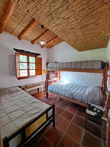 蒂尔卡拉Casa en Tilcara con hermosa galería的一间卧室设有两张床和木制天花板