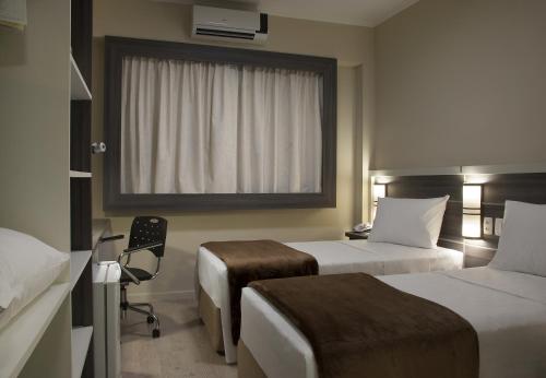 阿雷格里港Master Express Dom Pedro II的酒店客房设有两张床和窗户。