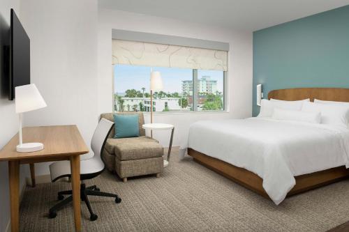 杰克逊维尔海滩Element Jacksonville Beach的一间卧室配有一张床、一张桌子和一把椅子