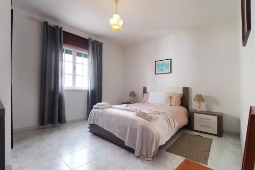 米尔芳提斯城Casa da Avó的白色的卧室设有床和窗户