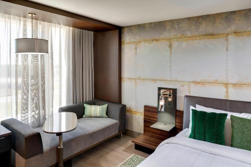 查尔斯顿北查尔斯顿万豪酒店的一间卧室配有一张床、一张沙发和一把椅子