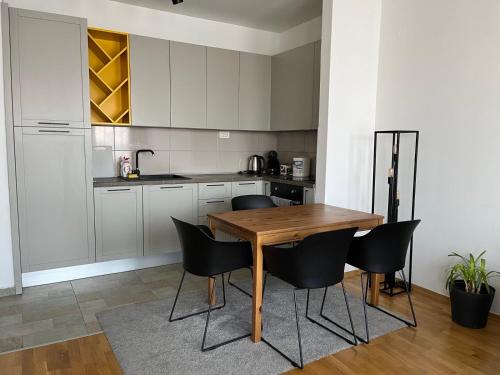 斯科普里Skopje LEKS apartment的厨房配有木桌和黑色椅子