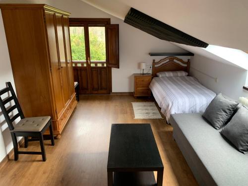 SevaresLa Buhardilla De Solavega - VV2530AS的客厅配有沙发和1张床