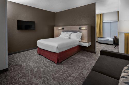 休斯顿休斯顿霍比机场春季山丘套房酒店的酒店客房,配有床和沙发