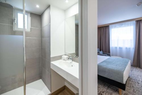 波尔多Sure Hotel by Best Western Bordeaux Lac的一间带水槽和淋浴的浴室以及一张床