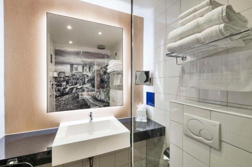 约克Radisson Hotel York的浴室配有盥洗盆、镜子和毛巾
