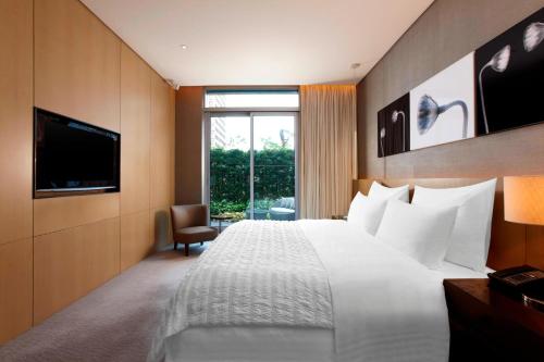 台北台北寒舍艾美酒店 的酒店客房,配有床和电视
